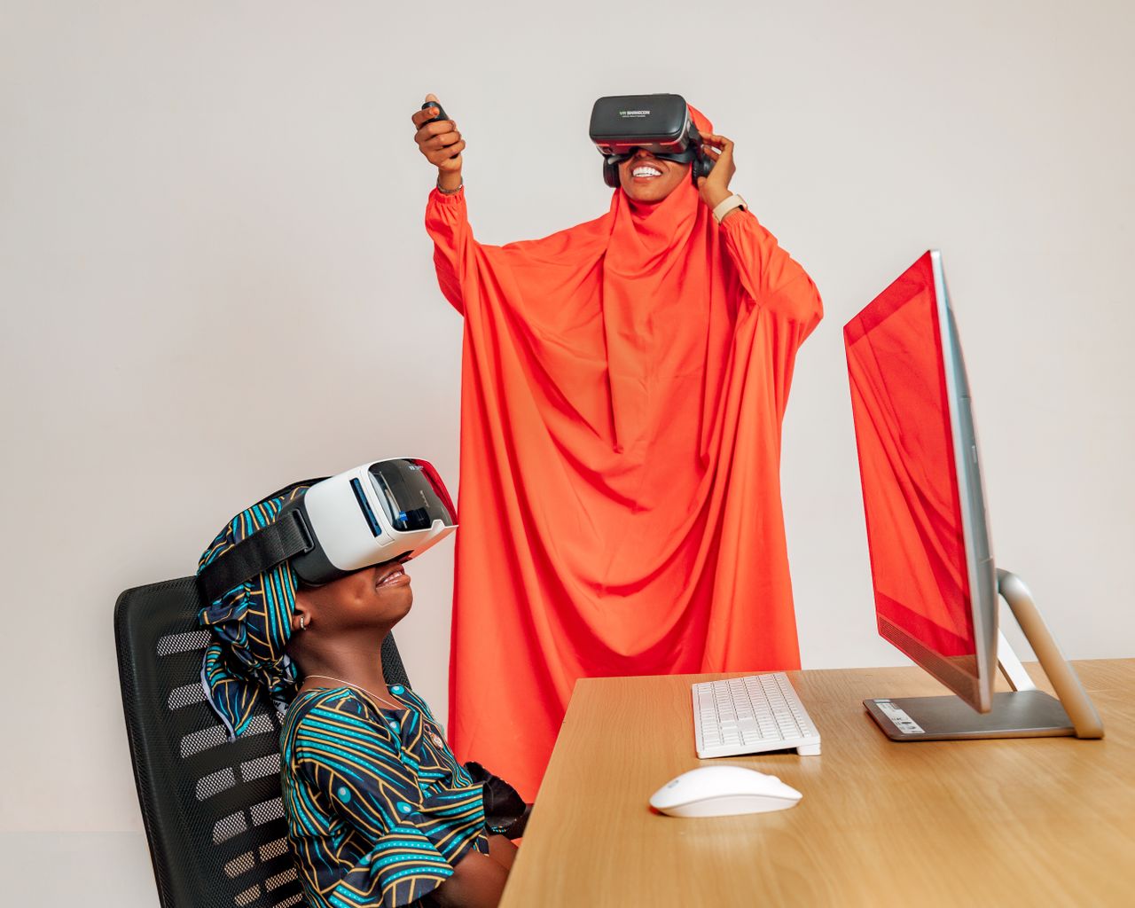 Services Two women enjoying VR technology indoors, combining traditional attire with modern virtual experiences.